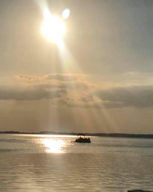sunset of lake eustis as a rental boat sails off