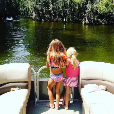 exploring the Dora Canal Eustis and Tavares Lake Adventures fl two sisters with back to camera standing on deck of pontoon boat overlooking the Dora Canal